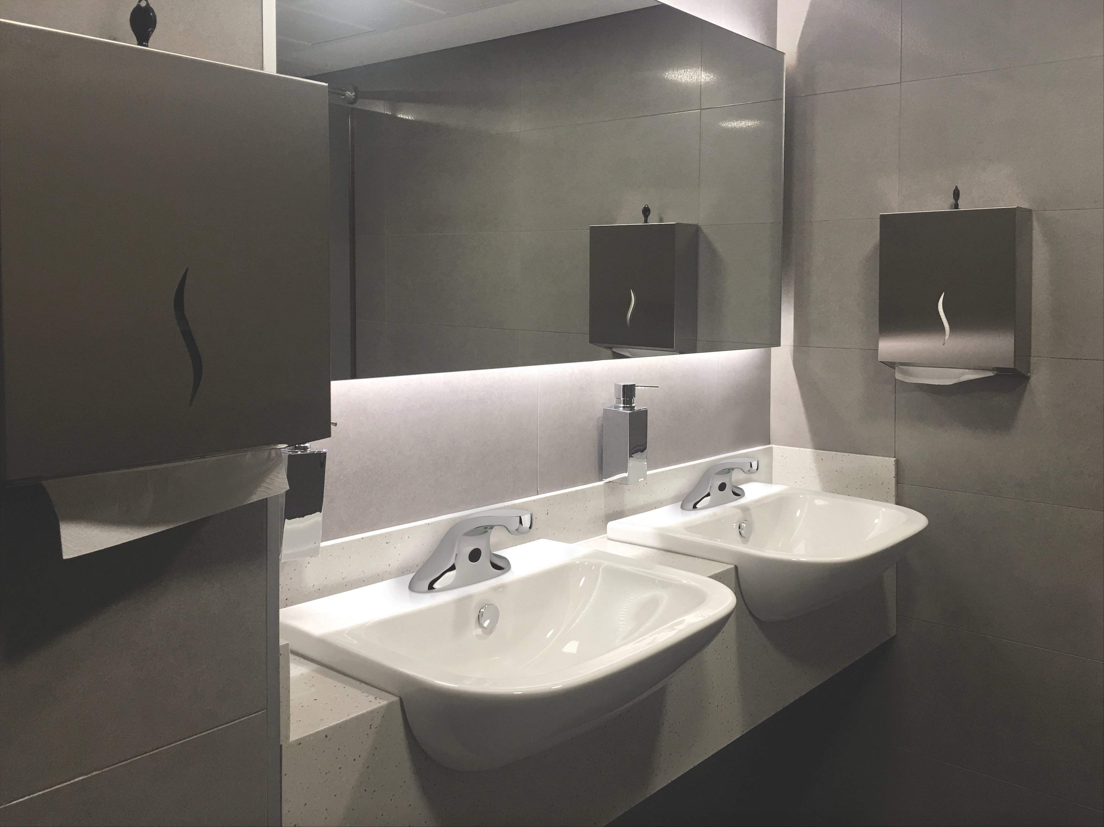 Image of a commercial restroom sinks with touchless faucets installed.