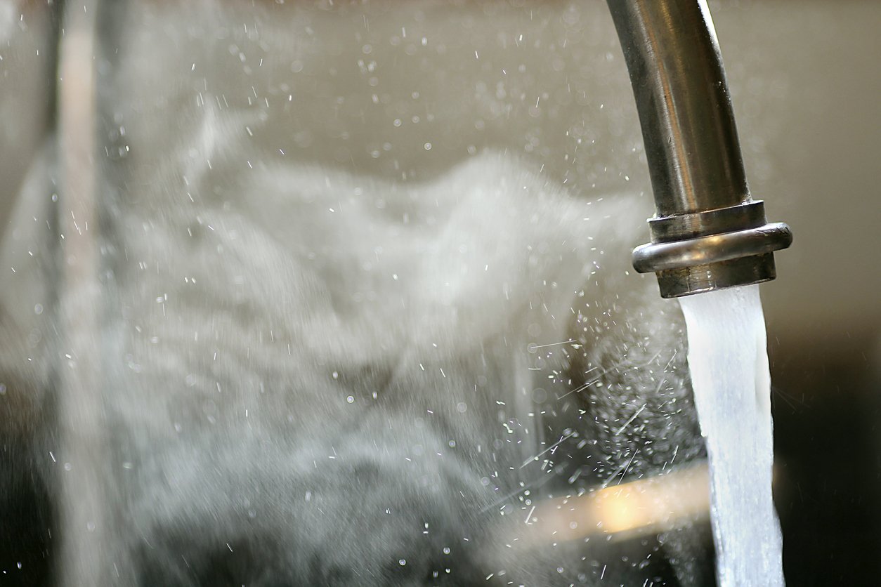 Image of a spout with hot steaming water dues to a lack of anti-scald faucets and valves.